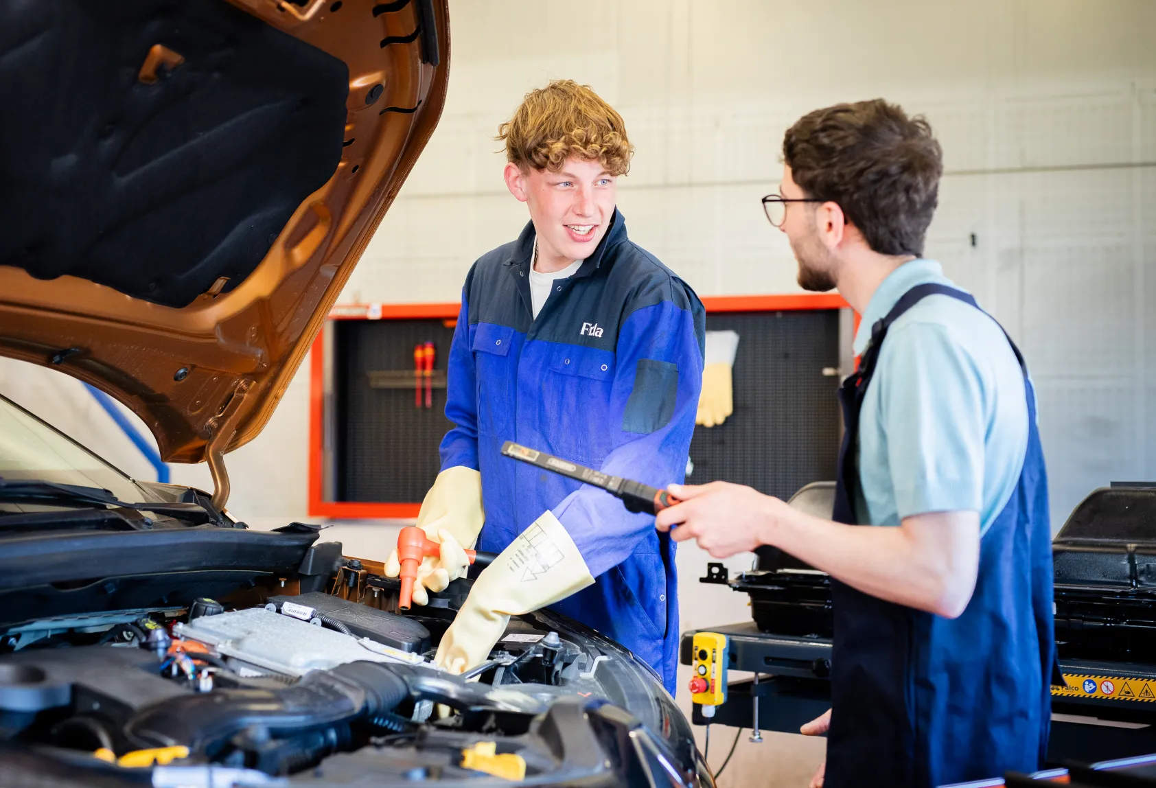Studenten Allround technicus personenauto's bij een elektrische auto aan het sleutelen bij Firda
