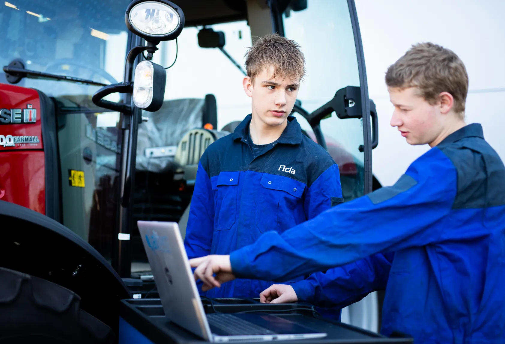 Student technisch specialist mobiele werktuigen leest een mobiel werktuig uit met een laptop en meetapparatuur bij Firda Heerenveen