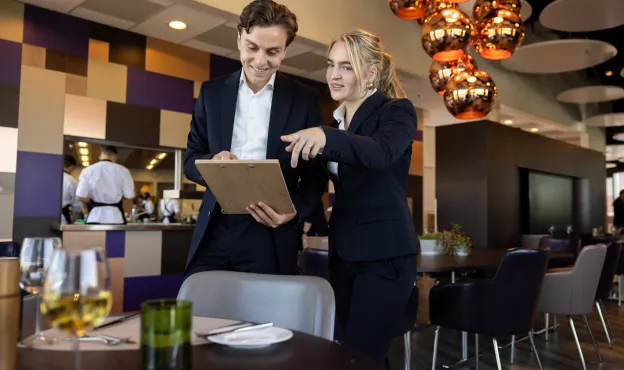 een gastheer en een gastvrouw met een clipboard