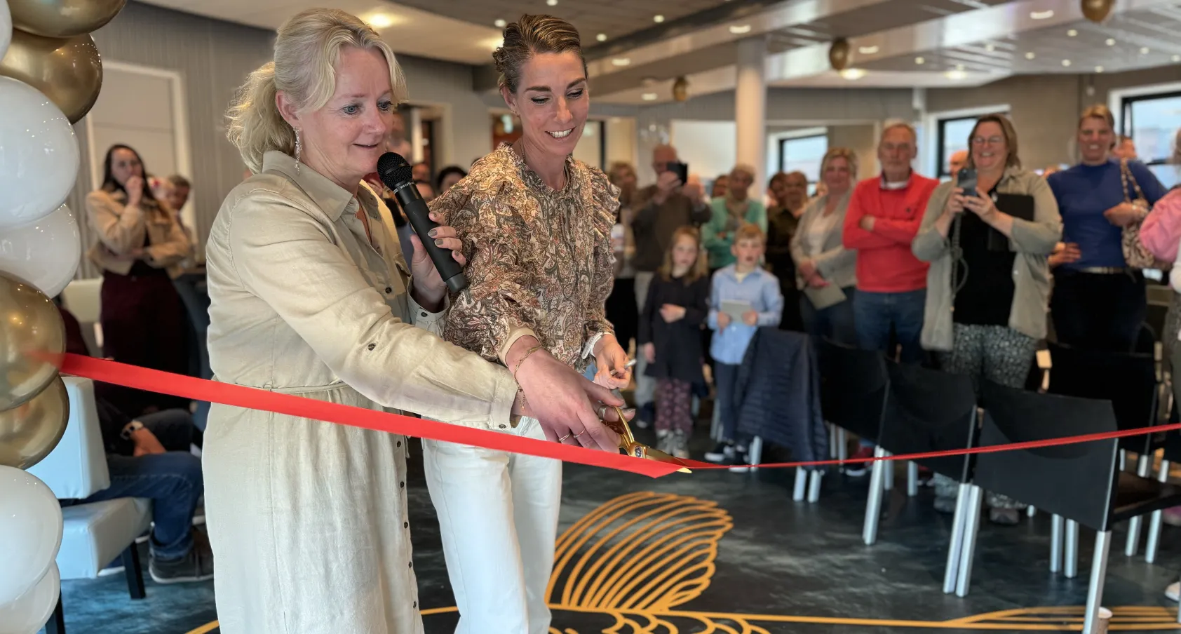 Directeur Minke Molenaar en teamleider Nelly van der Wal knippen lintje door tijdens opening Schoonheidssalon Firda Heerenveen